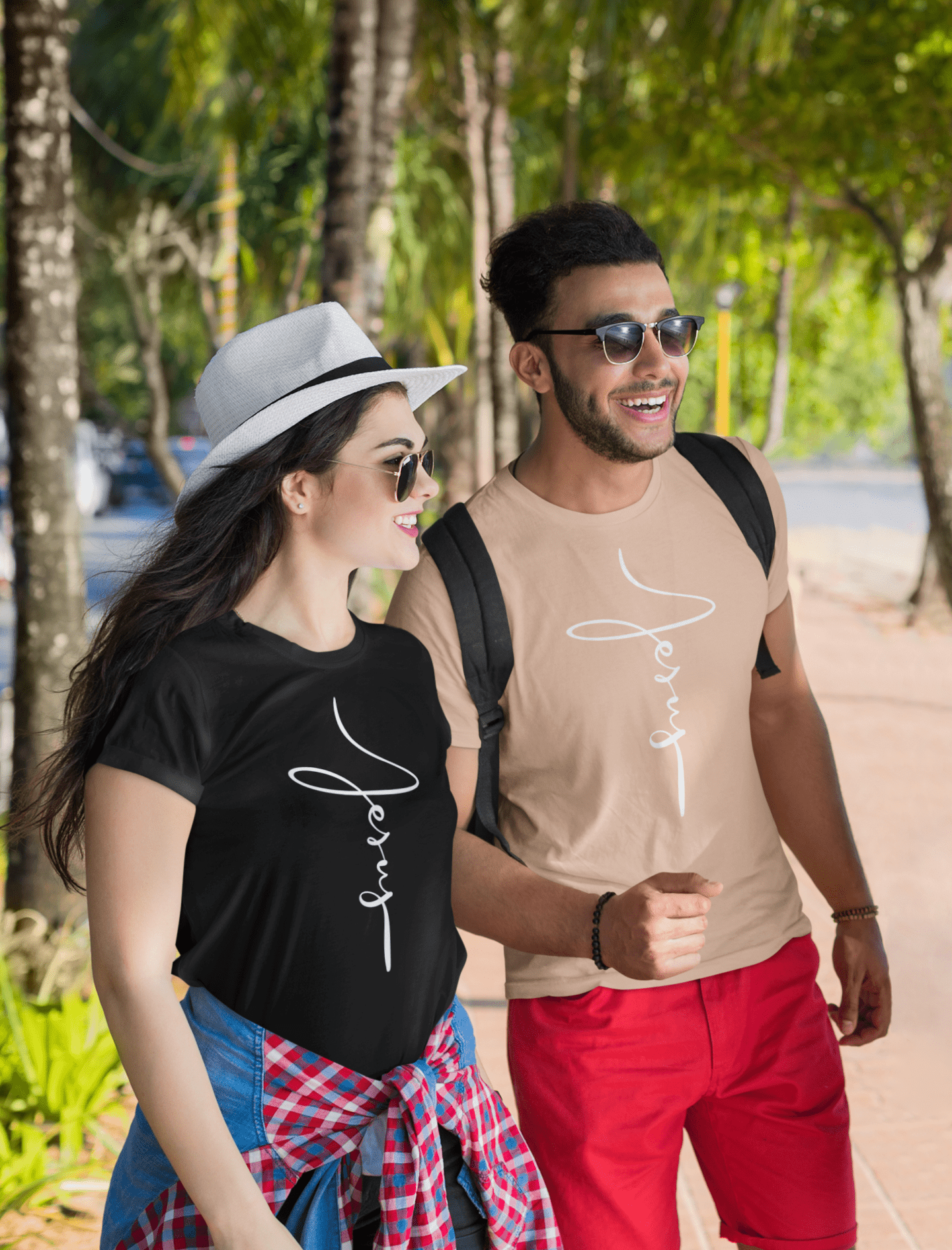 Jesus Cross Christian T-Shirt - Cursive White Font Neutral Color Tees Black on happy female, heather peach on happy male at the beach
